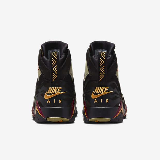 Rear view of black and gold Air Jordan shoes.